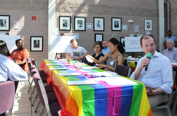 people sitting at a table with a rainbow flag on it