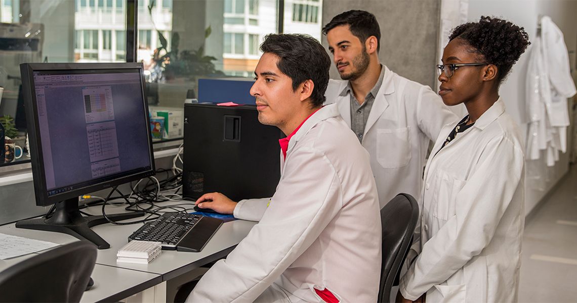 Researchers sitting in front of a computer