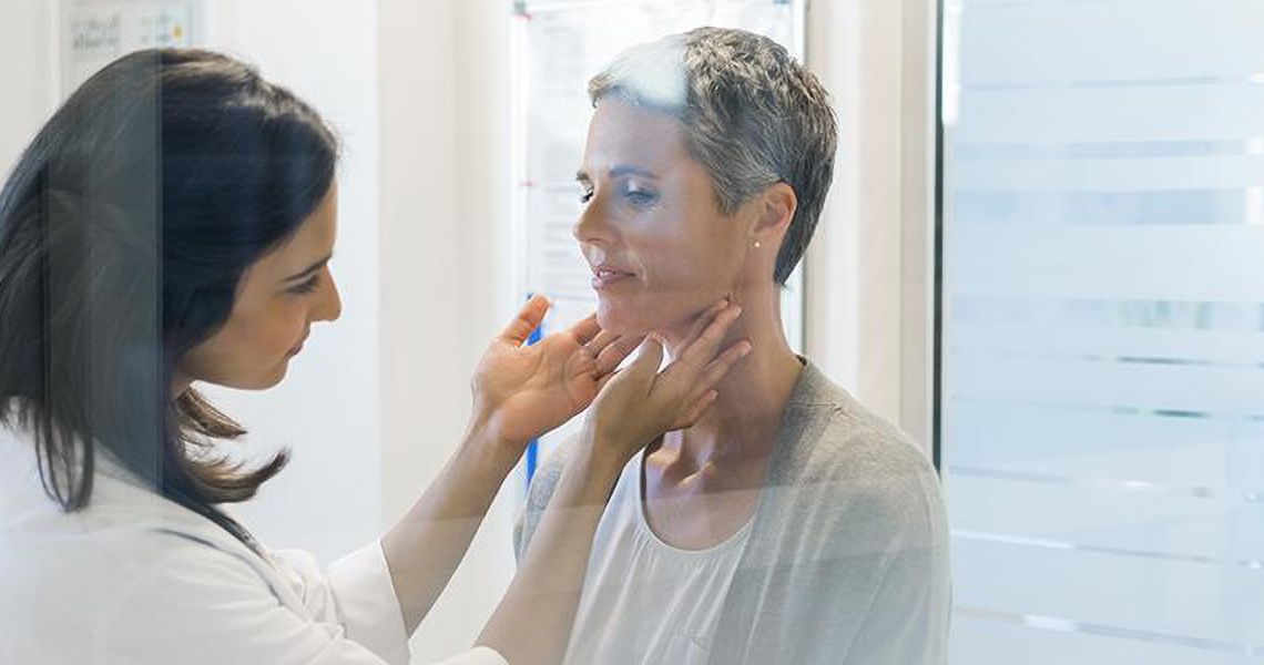 Doctor examining patient's neck