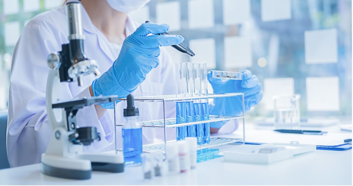 Oncologist in a lab with a microscope and test tubes