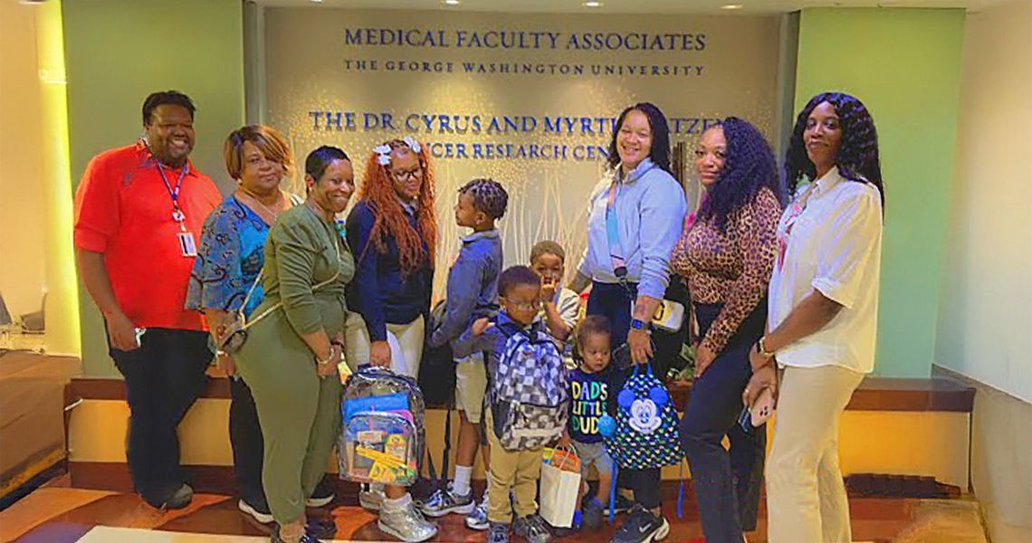 GW Cancer Center staff and patients and their children, with backpacks collected during the back to school drive.
