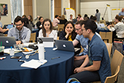 People sitting at tables in a hotel meeting room