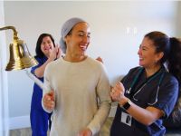 Happy cancer patient ringing the bell after successful treatment