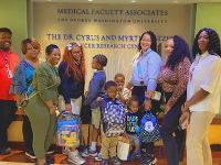 GW Cancer Center staff and patients and their children, with backpacks collected during the back to school drive.