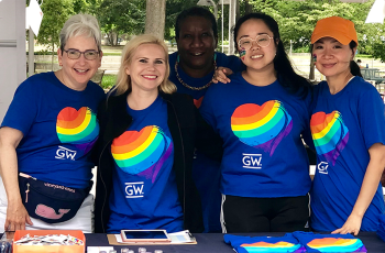 People standing in front of a table wearing pride GW shirts