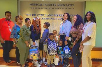 GW Cancer Center staff and patients and their children, with backpacks collected during the back to school drive.