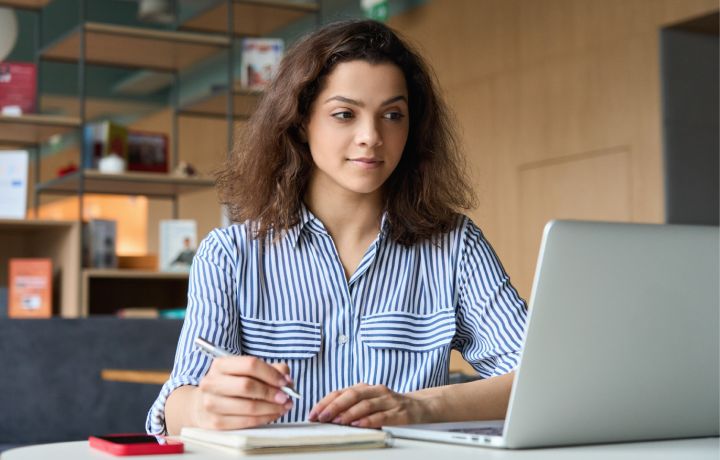 Young Latina woman watching a video on a laptop